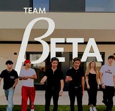 a group of young men standing next to each other in front of a building