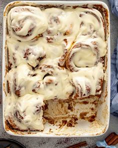 cinnamon rolls with icing in a white casserole dish