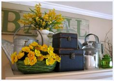 yellow flowers are in a basket on the mantle