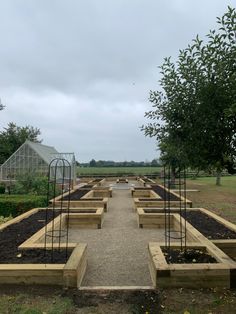 an outdoor garden area with raised beds and plants in the center, on a cloudy day