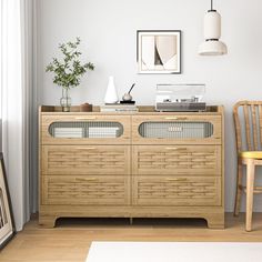 a living room with a wooden dresser and chair next to a wall mounted art piece