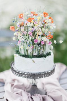 a white cake with flowers in it sitting on a table