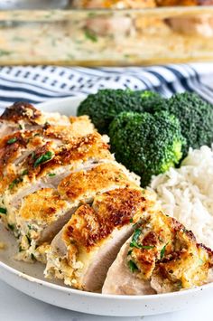 a white plate topped with chicken, rice and broccoli next to a casserole dish