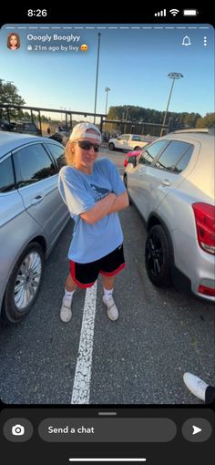 a woman standing in the middle of a parking lot with her arms crossed and looking at the camera