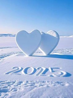 two white hearts shaped like the numbers 2013 and 2013 in snow on a sunny day