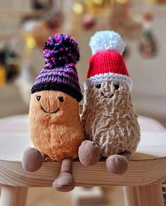 two small stuffed animals sitting on top of a wooden chair next to eachother