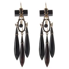 Composed of onyx, enamel and 14K gold, these antique pendant earrings were created around 1870. Each is designed as an onyx bar suspending a cascade of flexibly-set sphere, black enamel oval element and three tapering onyx drops with shaped enamel caps, accented by applied beads. Freely moving and magically lightweight, these fabulous antique earrings are delightfully intricate and beautiful. Product Details: Item #: ER-21022 Circa: 1870 Dimensions: 2.75" length x 0.75" width Materials: Onyx; Black Enamel; 14K Gold Macklowe Gallery Curator's Notes: Earrings and necklaces with elongated torpedo shape drops referenced Etruscan and Greek forms that had been imaginatively enlarged and reinterpreted by French and Italian Archaeological Revival jewelers such as Fontenay and Castellani. Red Priestess, Onyx Bar, Antique Pendant, White Dragon, Antique Earrings, Ear Jewelry, Black Enamel, Pendant Earrings, Onyx