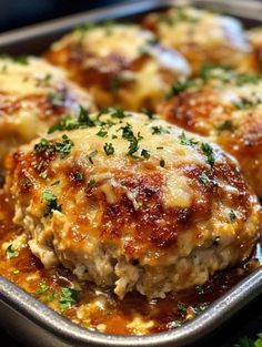 meatballs covered in marinara sauce and parmesan cheese on a baking sheet