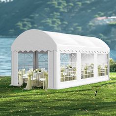 a white tent with tables and chairs set up in the grass