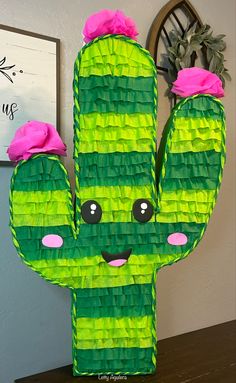 a green paper cactus with pink flowers on it