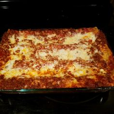 a square casserole dish with meat and cheese on top in an oven, ready to be cooked