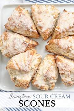 a white plate topped with scones covered in powdered sugar on top of a blue and white table cloth