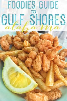 fried fish and fries on a blue plate with lemon wedges in the foreground