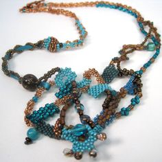 a beaded necklace is shown on a white surface with blue beads and gold chains