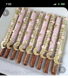 pink and gold decorated pretzels on a white platter with stars, moon and crescents