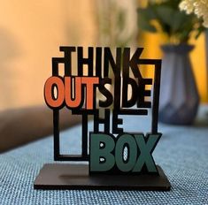 a table topped with a wooden sign that says think outside the box