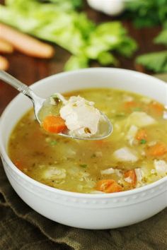 a white bowl filled with chicken and vegetable soup