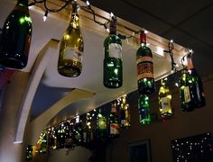 several wine bottles are hanging from the ceiling