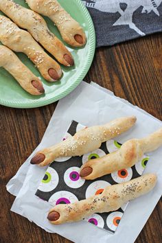 some bread sticks are sitting on a table next to a plate with sprinkles