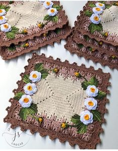 four crocheted coasters with flowers on them