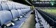 there are many blue seats in the stands at this soccer stadium, and one person is standing next to them