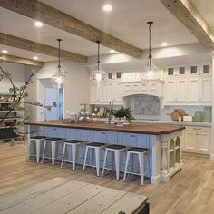 a large kitchen with white cabinets and wooden floors