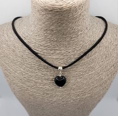 Lightweight and unique, Black Obsidian heart necklace. A gorgeous gift for a Birthday, Valentine's Day, Christmas or any special occasion.  A versatile necklace that can be worn daytime or evening, dress up or dress down. The black semi-precious Rainbow Obsidian heart bead is threaded onto a sterling silver bail and attached to black faux suede cord to make a gorgeous choker style necklace. The necklace fastens at the back with a sterling silver bolt ring clasp and features a 2 inch sterling silver extender chain (with tiny flat heart at the end) to adjust the length. [ All findings are 925 Sterling Silver ] Your necklace will come in an organza bag. [ Please be aware that natural crystals and semi-precious stones often have marks and perceived flaws; these are, in my opinion, part of thei Spiritual Black Jewelry For Valentine's Day, Black Necklace For Valentine's Day Gift, Black Charm Necklaces As Gift, Black Jewelry For Valentine's Day Gift, Black Heart Pendant Necklace As Gift, Valentine's Day Gift Black Charm Necklace, Black Spiritual Jewelry For Valentine's Day, Adjustable Black Heart Necklace As Gift, Black Charm Necklace For Valentine's Day Gift