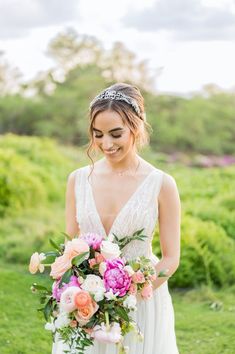 a woman in a wedding dress holding a bouquet and smiling at the camera with her eyes closed