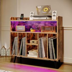 an old record player is sitting on top of a wooden shelf with records and cassettes