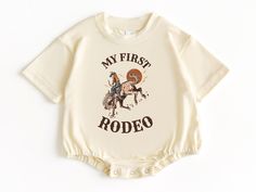 My First Rodeo T Shirt Bubble Romper, Rodeo Birthday, Baby Bodysuit, First Birthday Outfit, Birthday Boy Shirt, First Birthday Shirt 💗  Welcome to The WildflowerbyMiley Etsy Shop!  This listing is for the bodysuit, sweatshirt or t-shirt only. All other items that are shown in our photos such as shoes, hats, beanies, blankets etc. are for photo staging purposes and are NOT INCLUDED in the sale. DESCRIPTION:  This baby and children's unisex essential fits like a well-loved favorite. Super soft t- Summer Short Sleeve Onesie With Custom Print, Unisex Short Sleeve Onesie For First Birthday, First Birthday Short Sleeve Onesie, Summer Birthday Onesie With Short Sleeves, Family Matching Graphic Print Onesie For Birthday, Family Matching Graphic Print Onesie For Birthdays, Summer First Birthday Onesie With Name Print, Graphic Print Short Sleeve Onesie For Birthday, Graphic Print Onesie For First Birthday