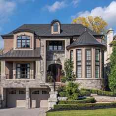 a large brick house with two car garages on the front and second story windows