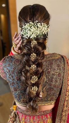 a woman with long hair and flowers in her hair, wearing a bridal hairstyle