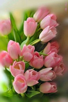 a bouquet of pink tulips sitting on top of a table