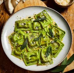 a white plate topped with pasta covered in pesto