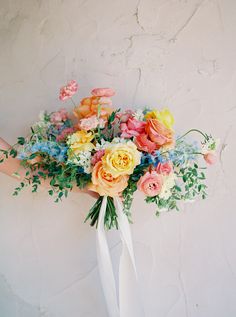 a bouquet of flowers is held up against a wall