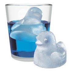 a glass with some ice in it next to a small plastic penguin figurine