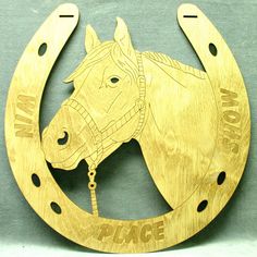 a wooden sign with a horse on it's face in the shape of a horseshoe