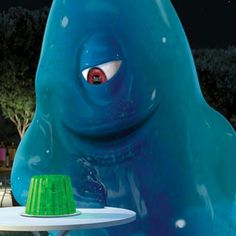 there is a cake on a plate in the shape of a giant blue monster with green icing