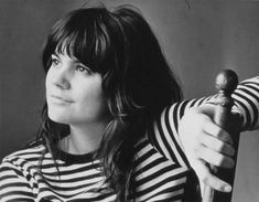 black and white photograph of a woman with long hair holding a small object in her hand