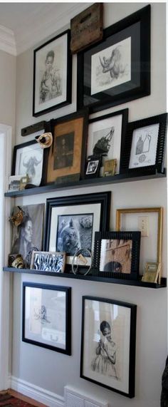 a wall with many framed pictures on it