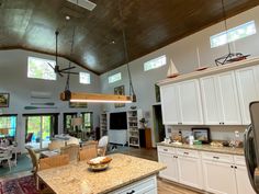 a large open concept kitchen and living room with an island in front of the dining area