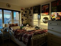 a bed room with a neatly made bed and lots of pictures on the wall