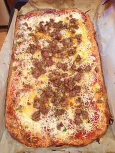 an uncooked pizza sitting on top of a pan covered in cheese and meat