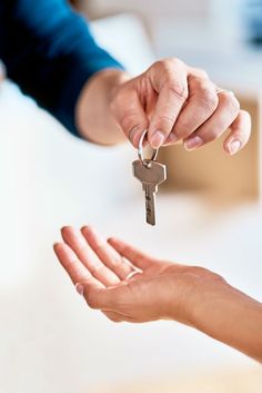 two people holding keys to each other in their hands