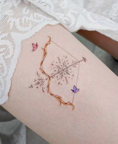 a woman's thigh with tattoos on it and butterflies flying around the tattoo design