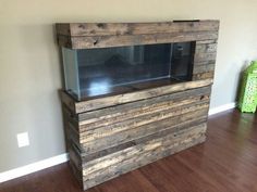 a fish tank sitting on top of a wooden cabinet in a room with hard wood floors