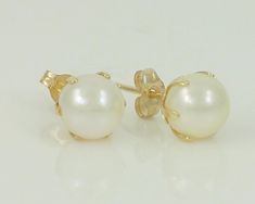 Vintage 14K Pearl Stud Earrings. Each earring features one round cultured Akoya pearl, approximately 6.4 mm in diameter in a six prong claw mounting on a post with butterfly backs for pierced ears. In very good vintage condition, witno damage noted. ERA: Retro, 1980s METAL/MATERIAL: 14K Yellow Gold, Cultured Akoya Pearls HALLMARK/HISTORY: 14K on posts and earring backs MEASUREMENTS: Pearls are approximately 6.4 mm in diameter. Condition: Very good vintage condition, with no damage notedgs. Previ 14k Gold Round Pearl Earrings, Yellow Gold Round Pearl Earrings With Prong Setting, 14k Gold Pearl Earrings With Prong Setting, Round Pearl Earrings With Prong Setting, Round Pierced Pearl Earrings For Anniversary, Anniversary Pearl Earrings Pierced, Classic White 14k Stamped Earrings, Birthstone Earrings, June Birthstone