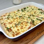 a casserole dish is sitting on a cutting board