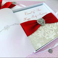 an open wedding card with a red bow