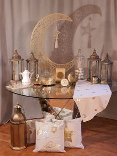 a glass table topped with lots of gold and white items on top of a hard wood floor